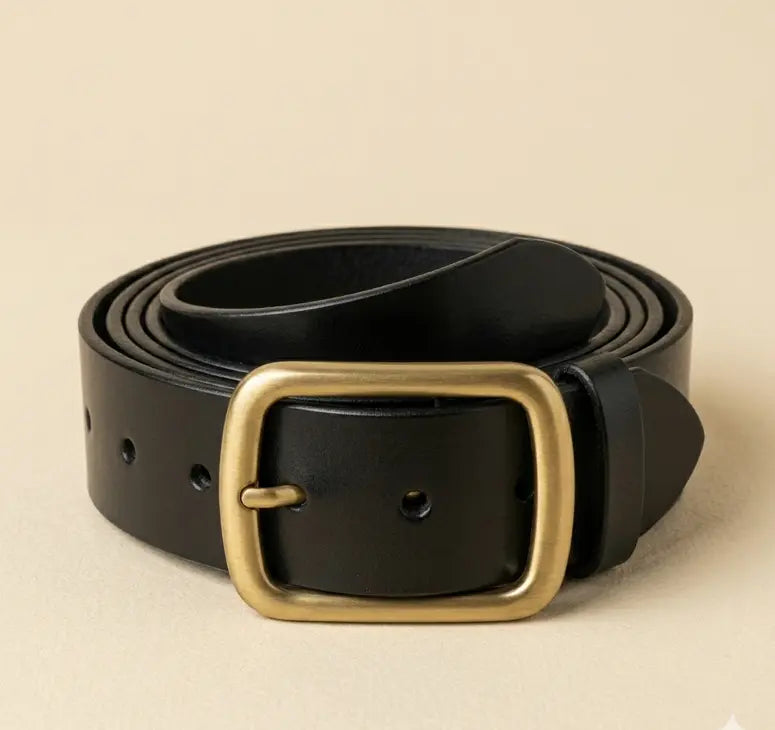 Black leather belt with a gold buckle on a beige background