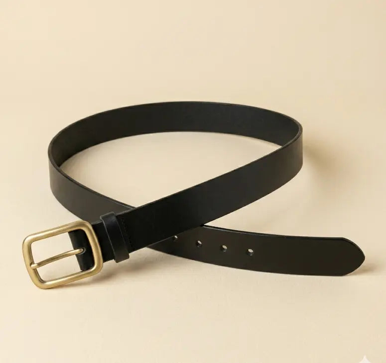 Black belt with a gold buckle on a beige background