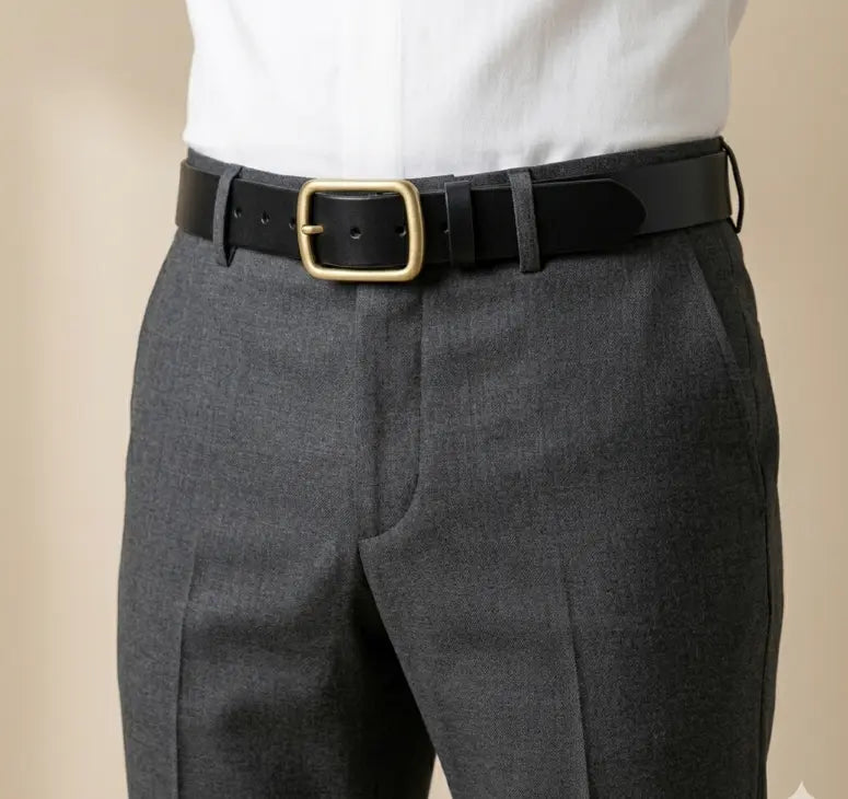 Gray pants with a black belt and gold buckle on a beige background