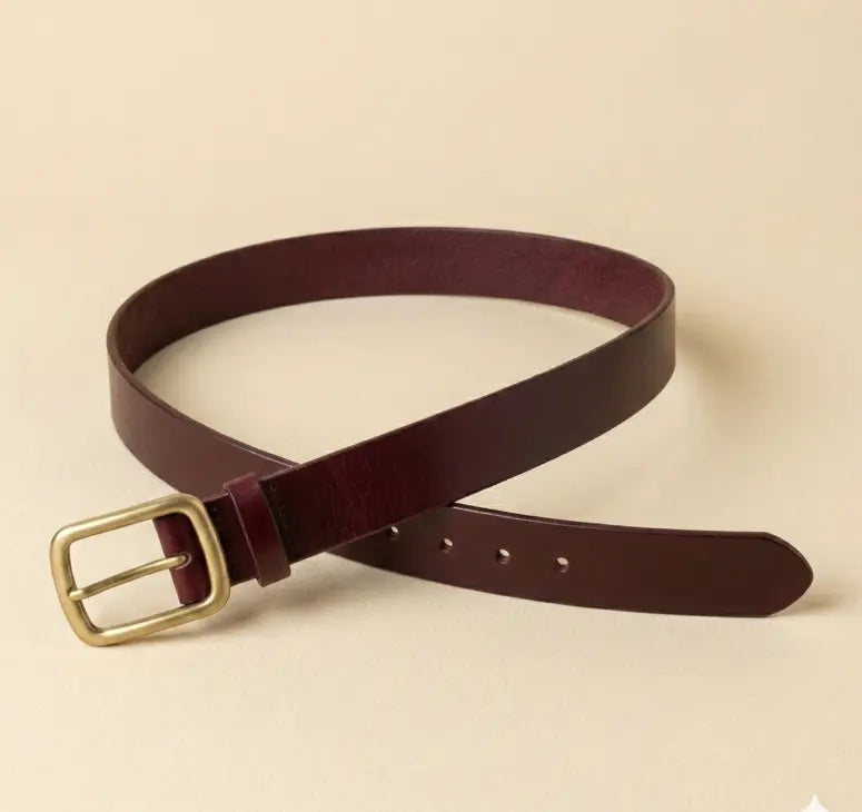 Brown leather belt with a gold buckle on a beige background