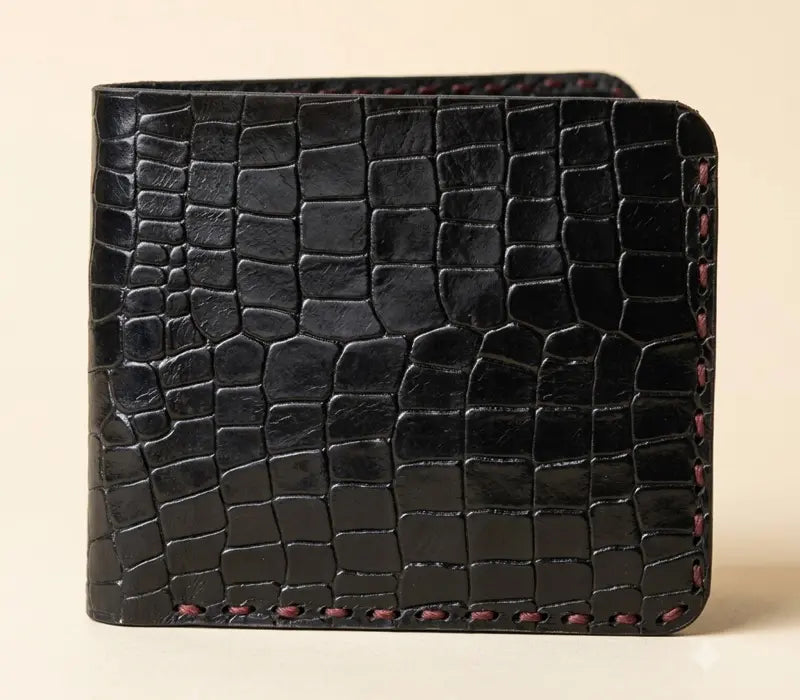 Black textured wallet on a beige background