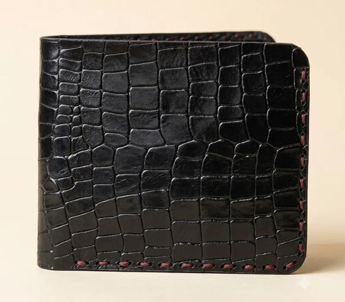 Black textured wallet on a beige background