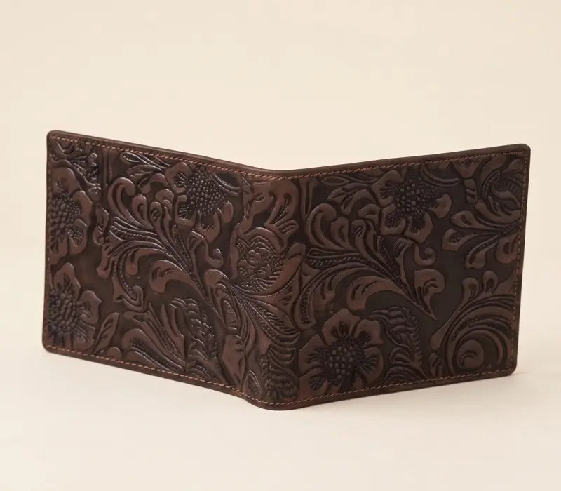 Brown leather wallet with floral embossing on a beige background