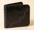 Black leather wallet with red stitching on a beige background