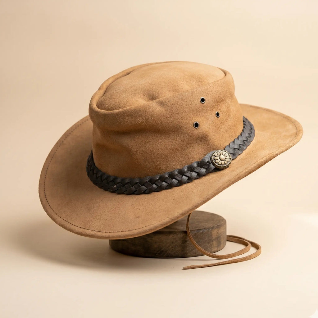 Brown cowboy hat with a braided leather band on a beige background
