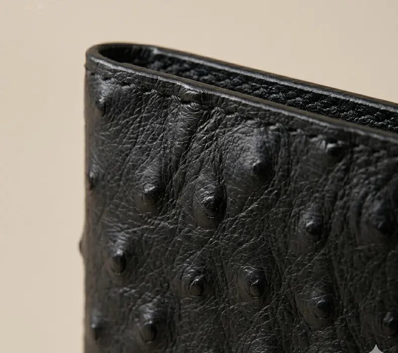 Close-up of a black textured wallet on a beige background