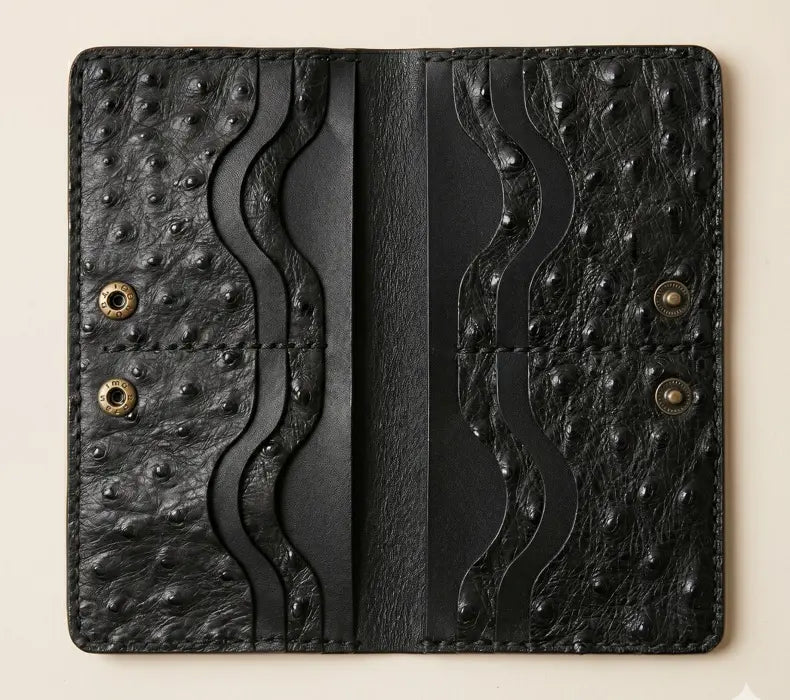 Black leather wallet with textured design on a beige background