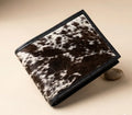 Brown and white cowhide wallet on a beige background