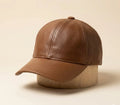 Brown leather cap on a wooden block against a beige background