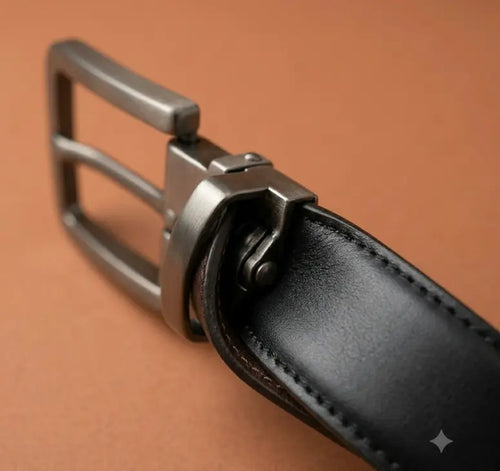 Close-up of a black leather belt with a silver buckle on a brown background