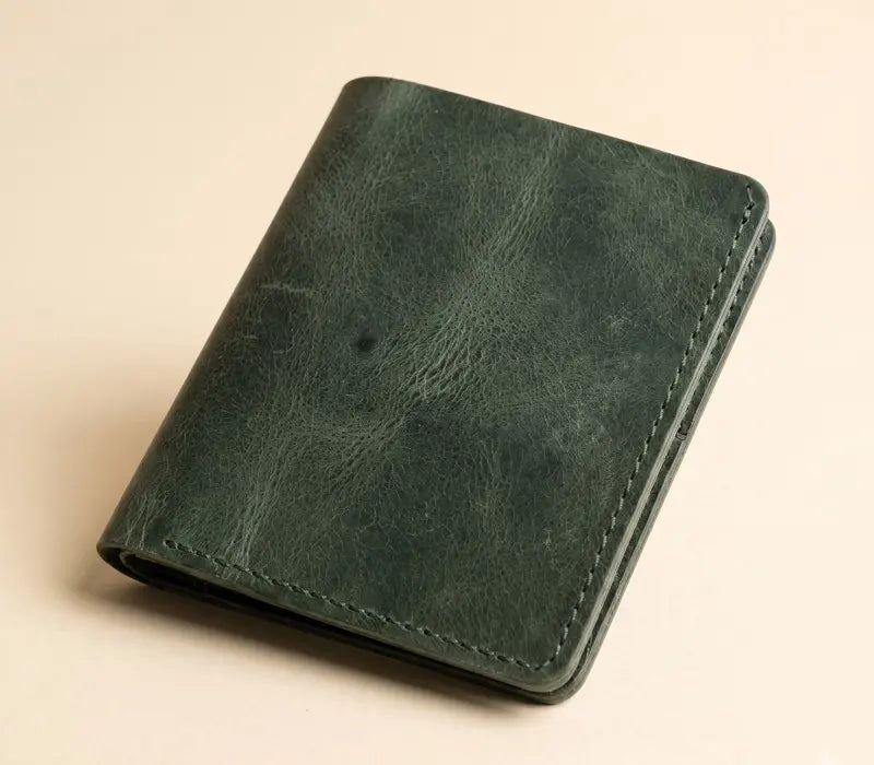 Green leather wallet on a beige background