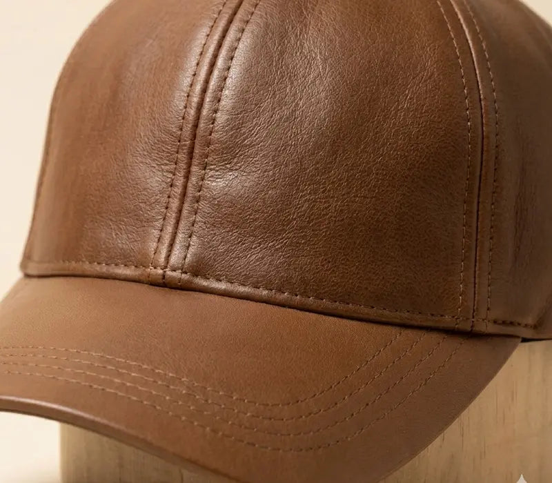 Brown leather baseball cap on a wooden surface