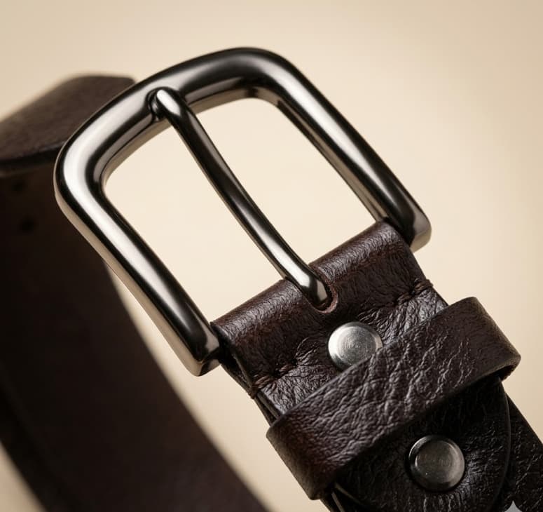 Close-up of a brown leather belt with a silver buckle on a beige background