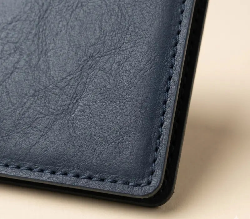 Close-up of a blue leather wallet corner on a beige background