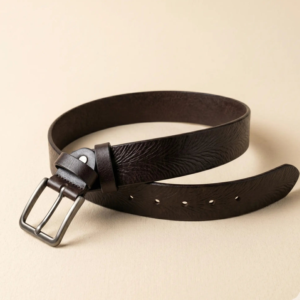 Brown leather belt with a silver buckle on a beige background