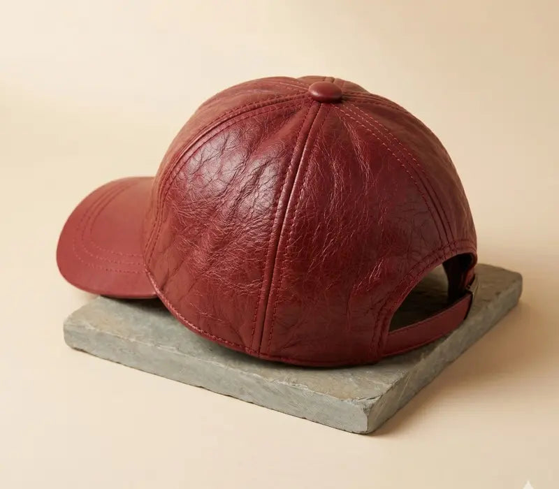 Brown leather baseball cap on a wooden stand with a beige background