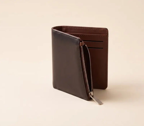 Brown leather wallet with a zipper on a beige background
