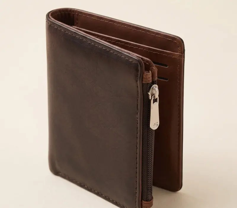 Brown leather wallet with a zipper on a beige background