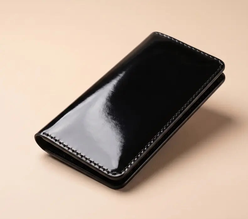 Black leather wallet on a beige background
