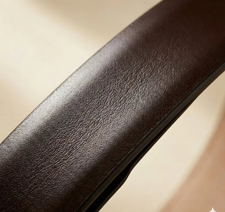 Close-up of a brown leather armrest on a beige background