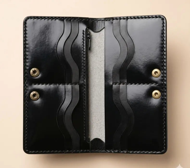 Black leather wallet with gold accents on a beige background