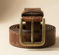 Brown leather belt with brass buckle on a beige background