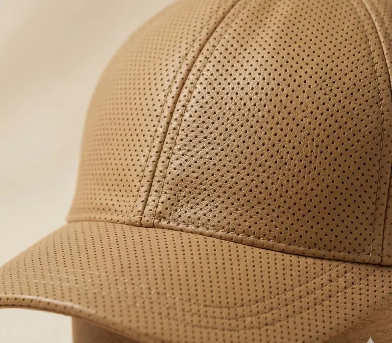 Close-up of a beige cap with perforated design on a beige background