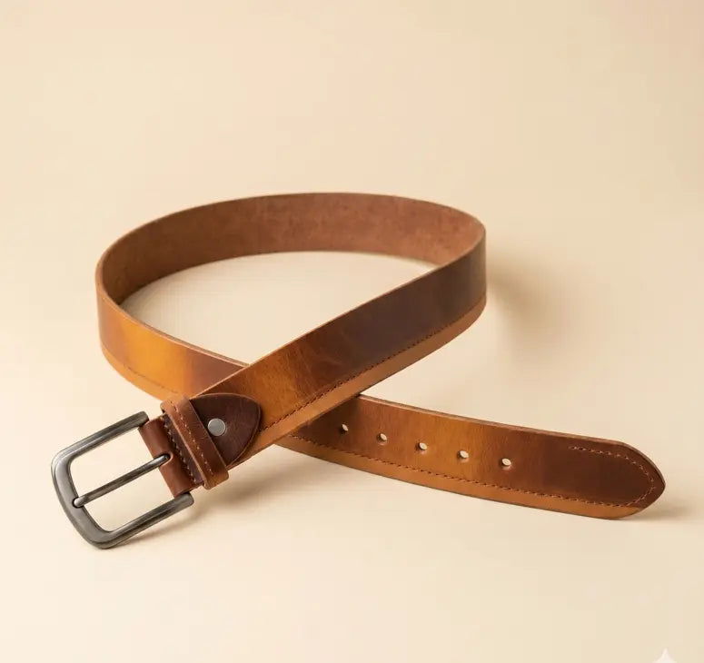 Brown leather belt with a black buckle on a beige background