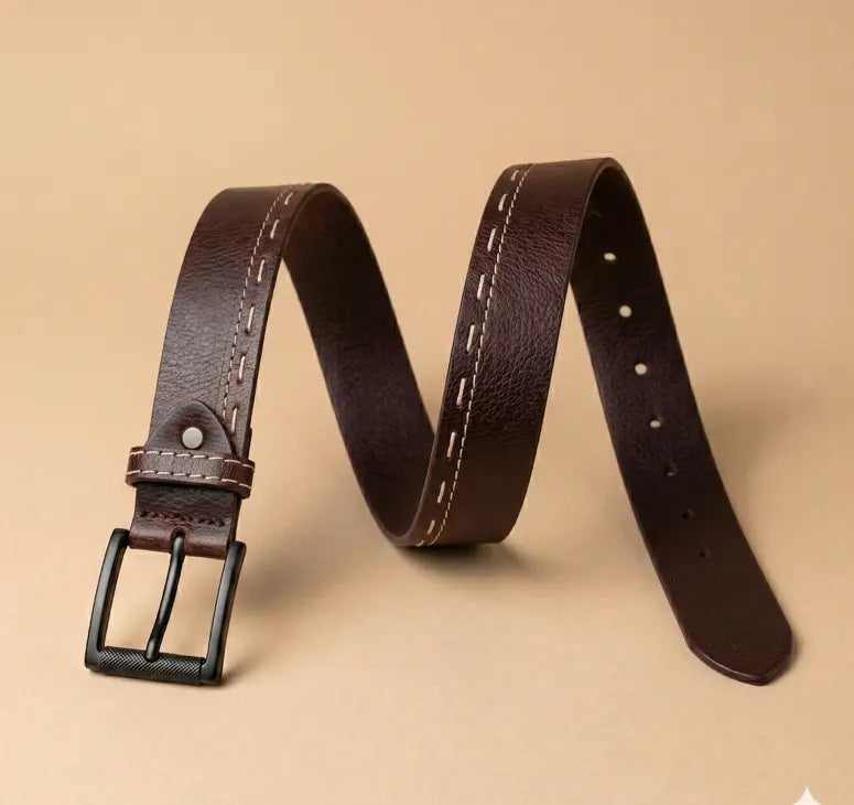 Brown leather belt with black buckle on a beige background