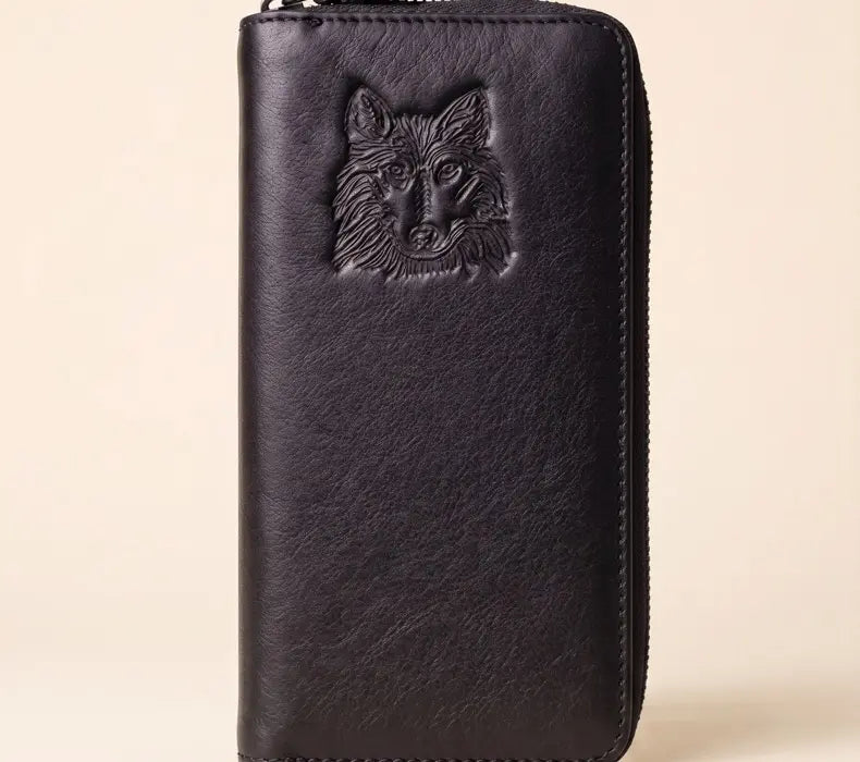 Black leather wallet with a wolf embossing on a beige background
