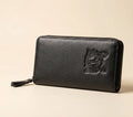 Black leather wallet with tiger emblem on a beige background