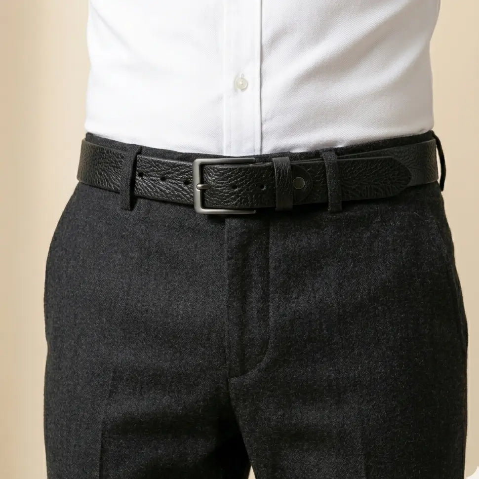 Dark gray pants with a black belt and white shirt on a beige background
