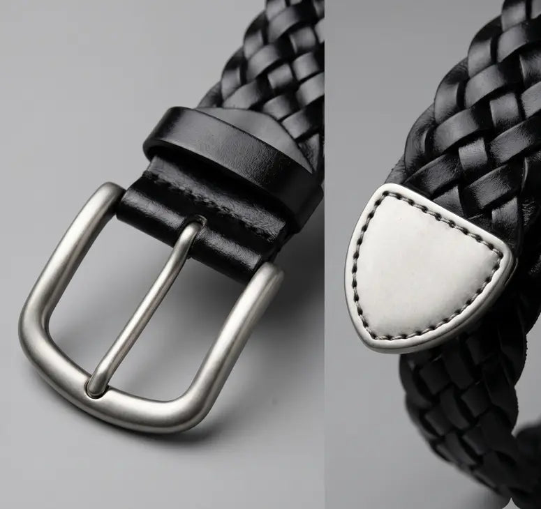 Black woven belt with silver buckle on a gray background