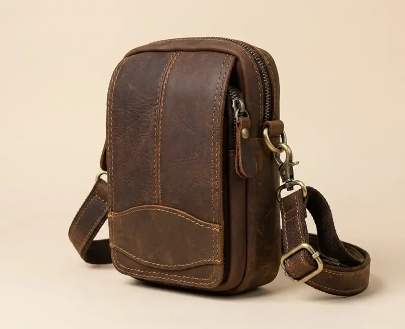 Brown leather crossbody bag on a beige background