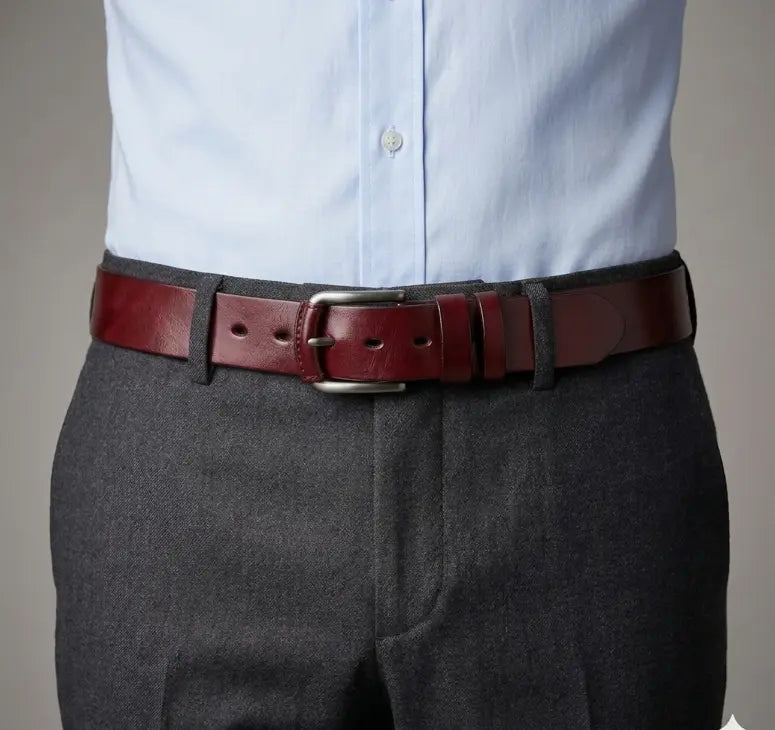 Person wearing a red belt with a gray shirt and dark pants on a neutral background